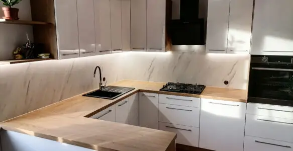 Kuchnia z białymi frontami i drewnianym blatem