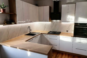 Kuchnia z białymi frontami i drewnianym blatem