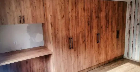 Zabudowa z szafą i biurkiem w kolorze drewna