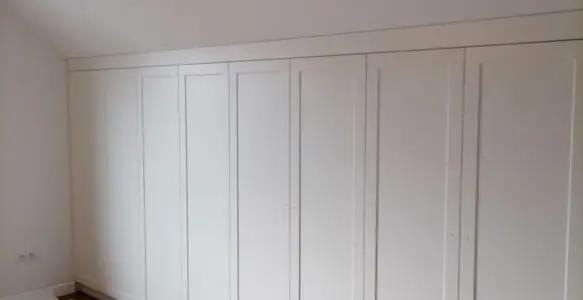 Biała szafa pod skosem z klasycznymi frontami