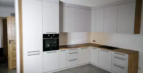 Kuchnia biała w układzie L z blatem w stylu drewnianym