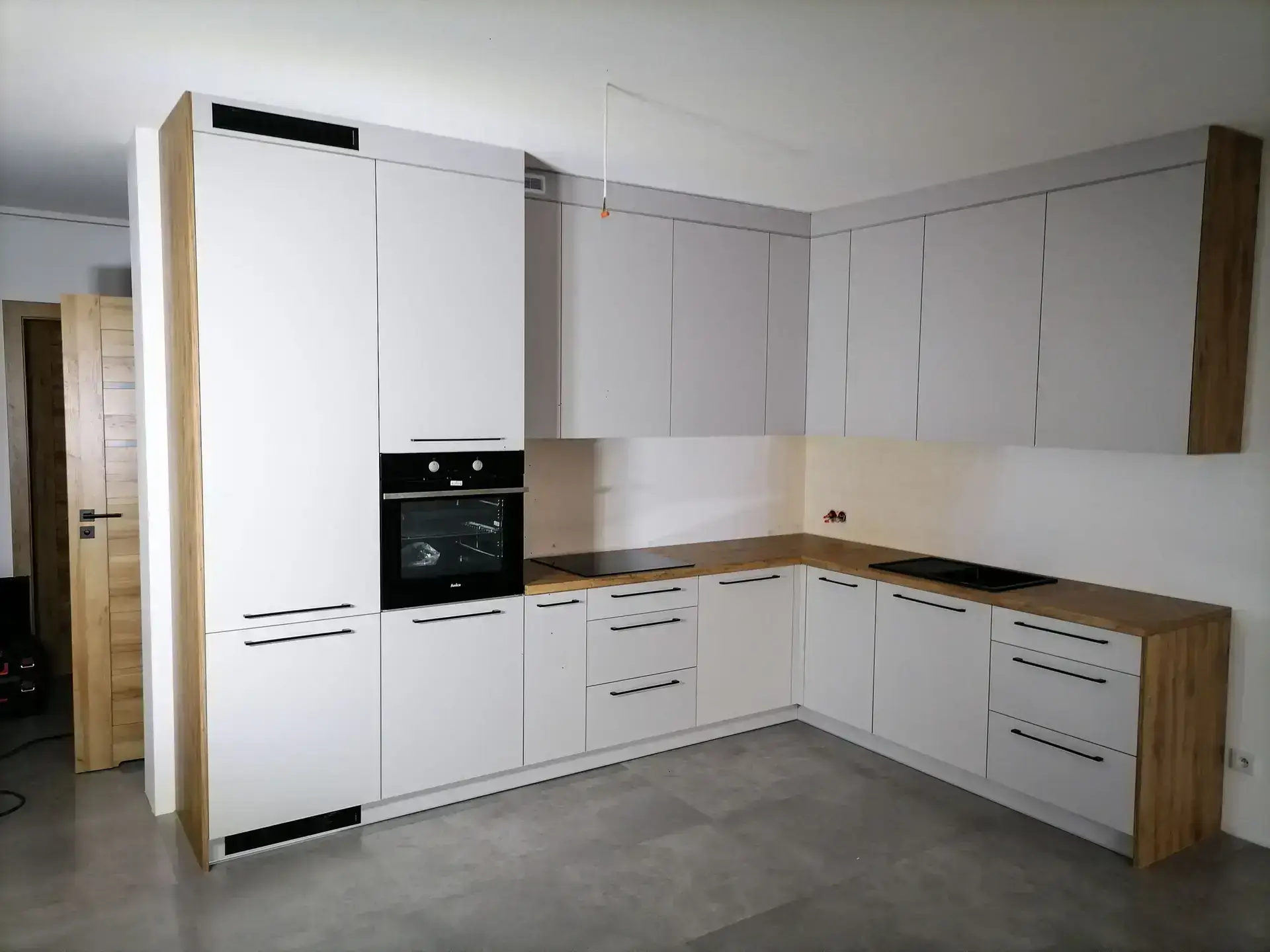 Kuchnia biała w układzie L z blatem w stylu drewnianym