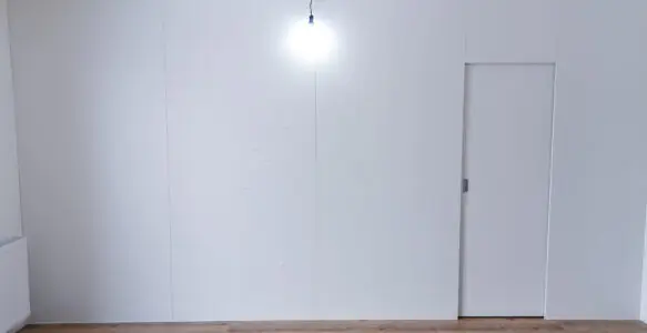 Zabudowa ściany z ukrytymi drzwiami i garderobą