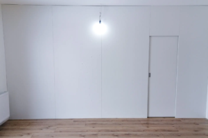 Zabudowa ściany z ukrytymi drzwiami i garderobą