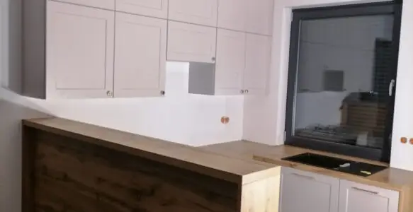 Kuchnia beżowo-drewniana z frontami ramkowymi