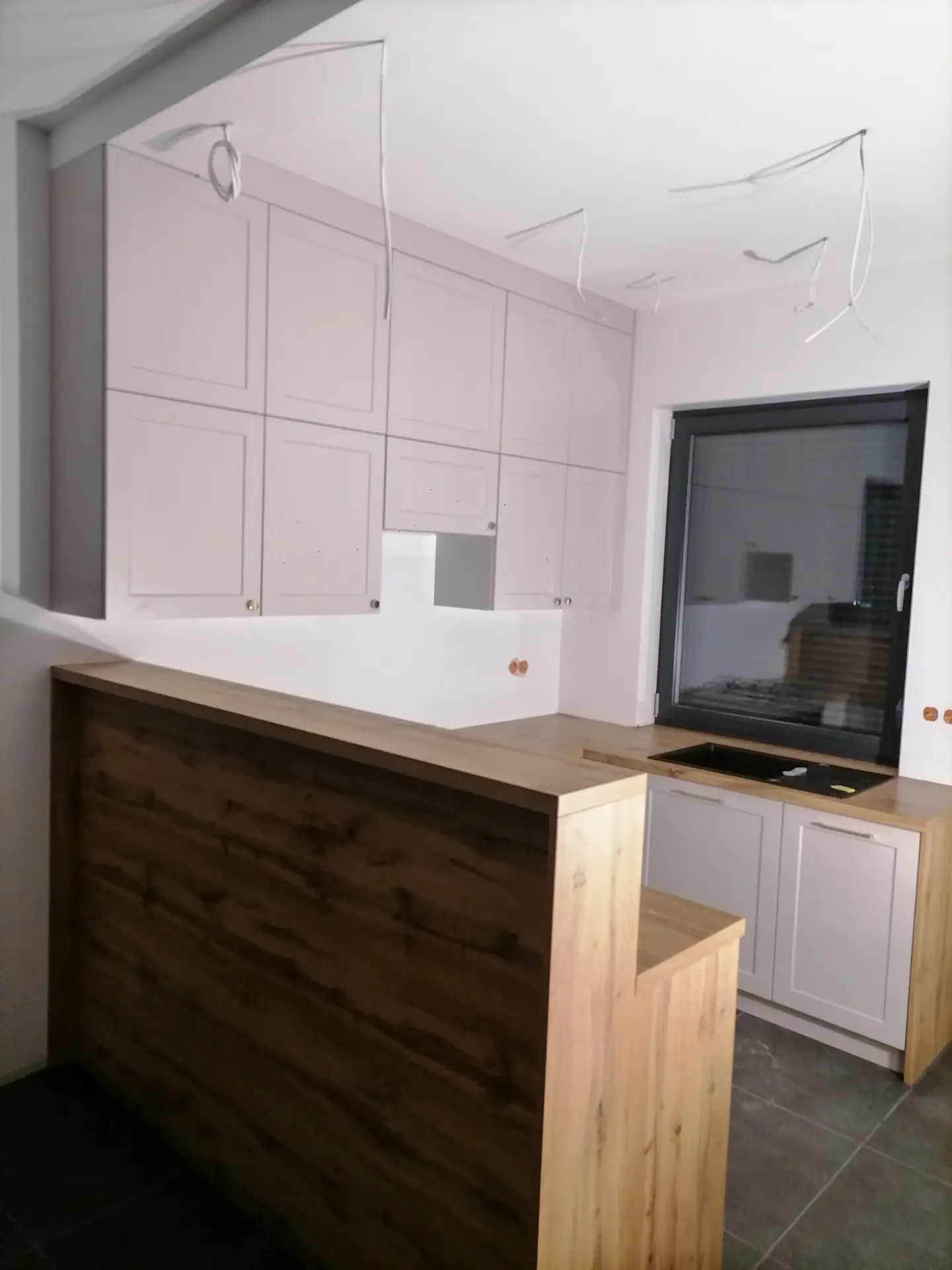 Kuchnia beżowo-drewniana z frontami ramkowymi